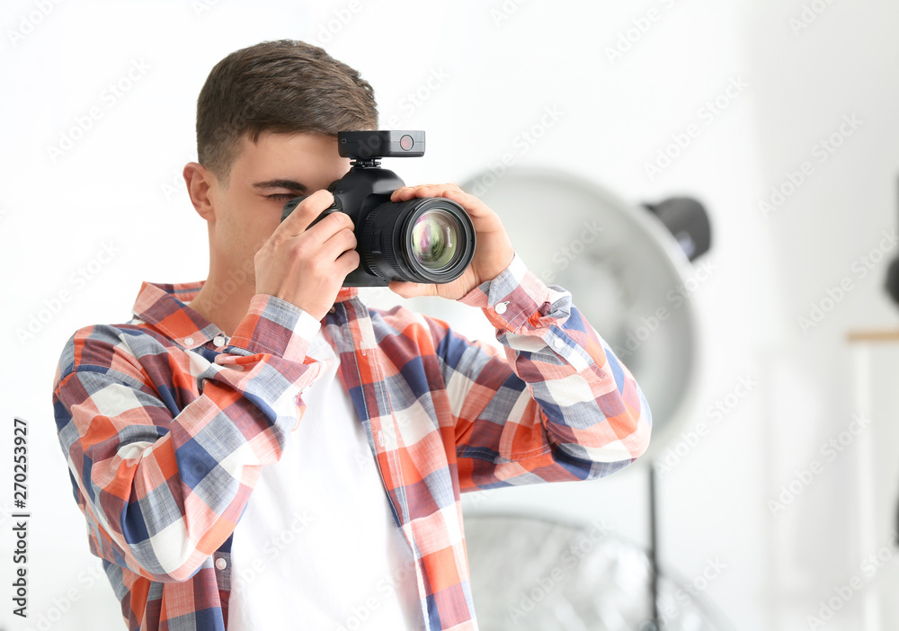Obraz premium Young male photographer working in studio