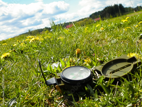 Compass on the meadow - travel and vacations concept.
