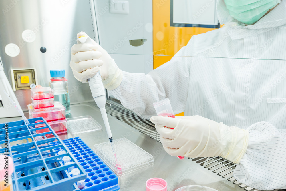 Poster A scientist seeding cells and pipetting growth medium into 96 ...