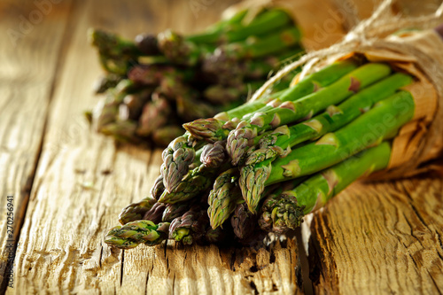 Fresh green asparagus on yellow wooden table 