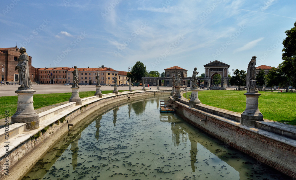 the oval canal around the fountain in Prato della Valle in Padua, Italy. Big old church.