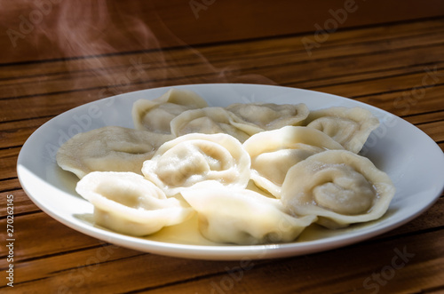 dumplings in a plate on a table close-up and white steam