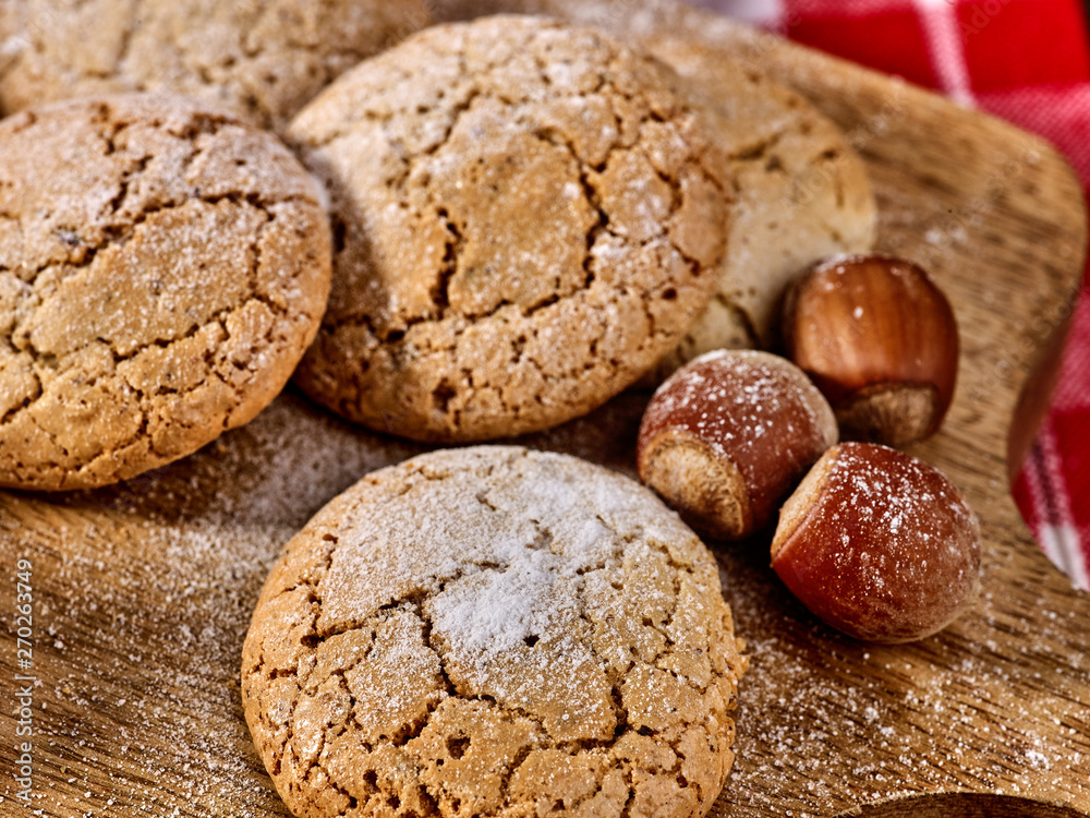 Oatmeal cookies and nut cookies with crack pattern on cutting board on table in rustic style. Hazelnuts in the peel.