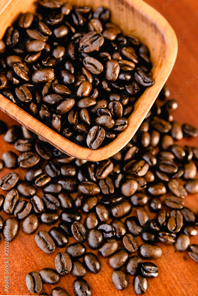 Fototapeta premium Coffee Beans In A Wooden Bowl On Rich Wood Background