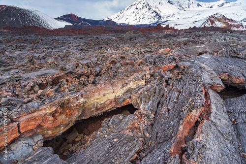 Fresh lava field. Mountain in the background. Kamchatka Peninsula, Russia.