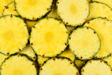 Pineapple juicy yellow slices background. Top view.