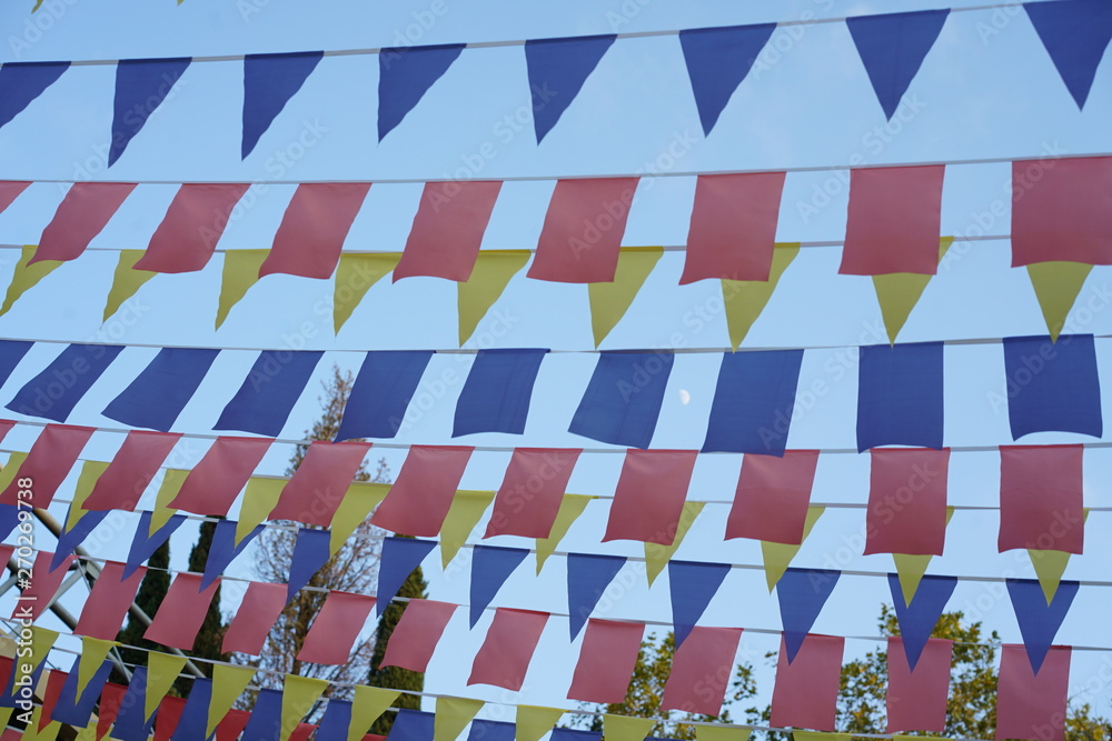 Bright colored paper pennons on the lines fluttering on the wind. Pennant flag strings.