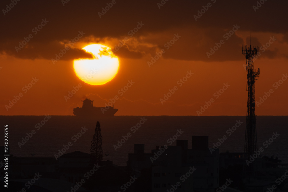 Sunrise over a cargo ship in clody skies Sunrise over a cargo ship in clody skies