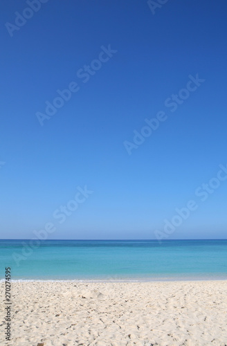 Sandy tropical beach with turquoise sea and clear blue sky travel background © allister