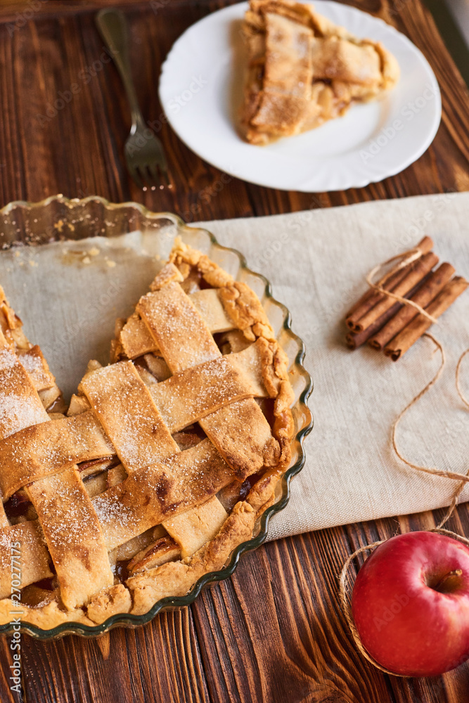 Tasty homemade apple pie. American pie. Apples. Cinnamon. Plate. Linen towel. Wooden background. Top view Tasty homemade apple pie. American pie. Apples. Cinnamon. Plate. Linen towel. Wooden background. Top view