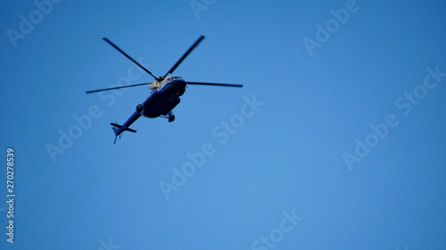 Fototapeta Naklejka Na Ścianę i Meble -  Blue and silver police helicopter flying above
