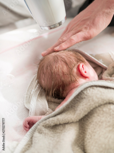 Father drying hair of newborn girl photo