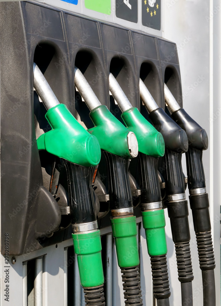 Close-up gasoline pistols on column for refueling.