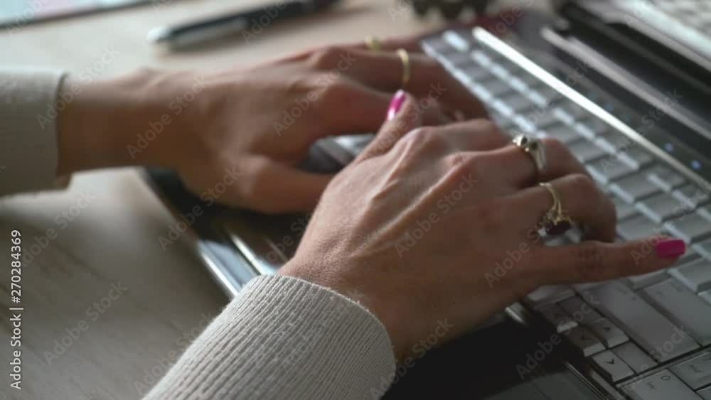 desplazamiento de izquierda a derecha de la camara donde se observa las manos de una mujer tecleando una computadora