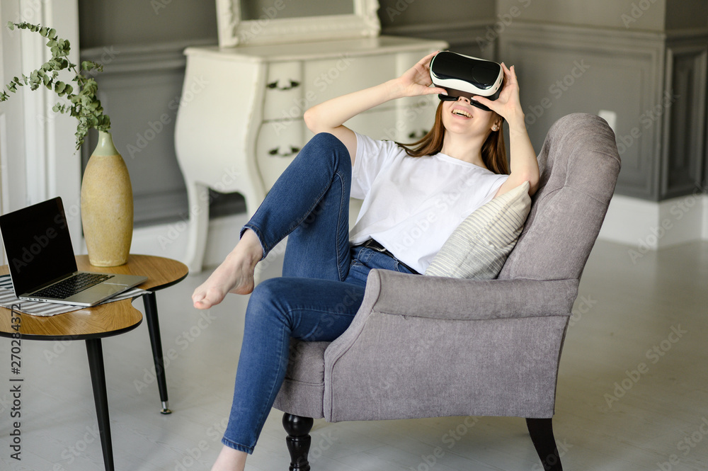 young woman uses virtual reality glasses in beautiful flat young woman uses virtual reality glasses in beautiful flat