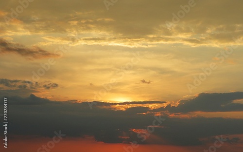 Beautiful golden sunset with black clouds on horizon, natural background © natalya2015
