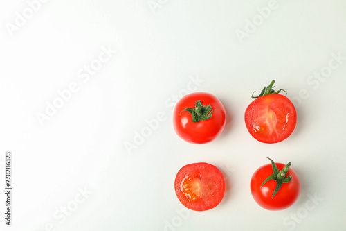 Flat lay composition with fresh cherry tomatoes on white background, space for text. Ripe vegetables