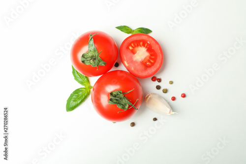 Fresh cherry tomatoes with basil, pepper and garlic on white background, space for text and top view. Ripe vegetables
