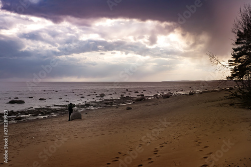 Terrible sunset on lake Ladoga. Footprints in the sand.