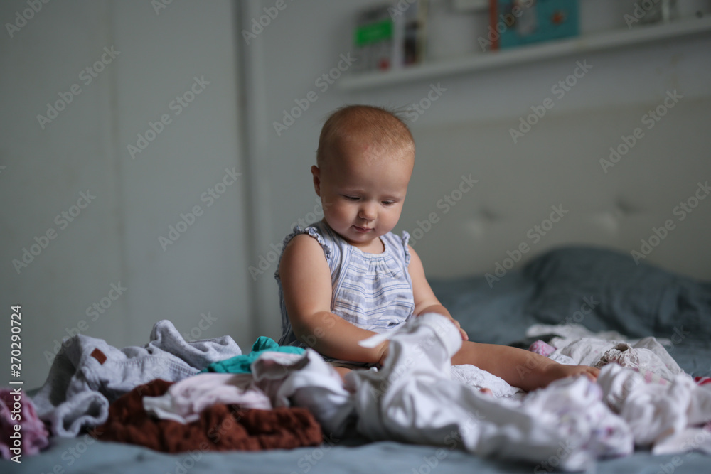 big pile of clean clothes and baby playing