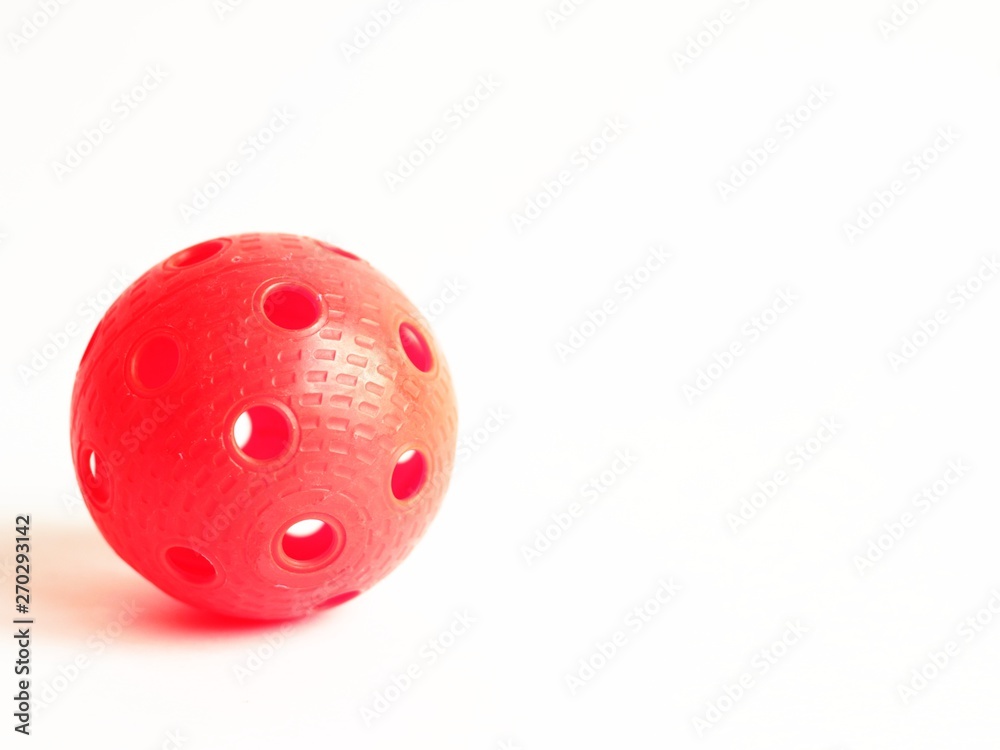 physical education and sport concept. sports games. red floorball ball on white background. copy space for text. physical education and sport concept. sports games. red floorball ball on white background. copy space for text.