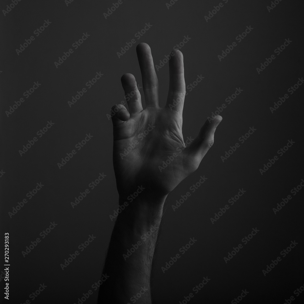 Male open hand gesture on a dark background Male open hand gesture on a dark background