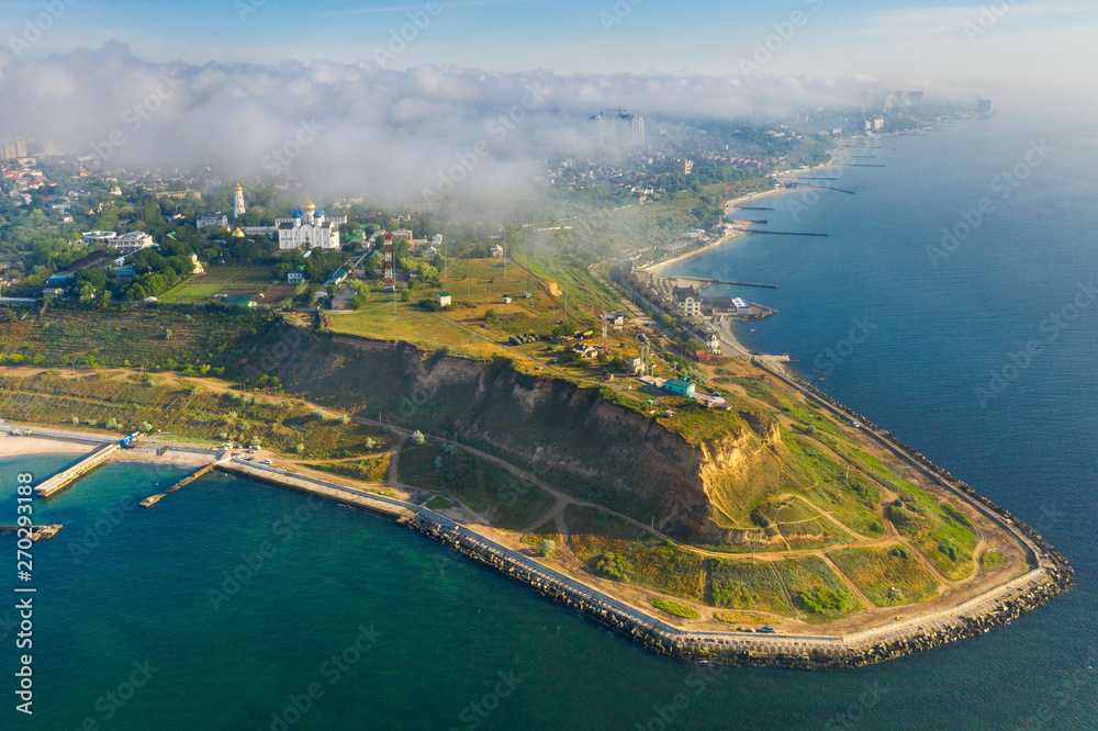 aerial view to curved cape with city in the fog in spring morning