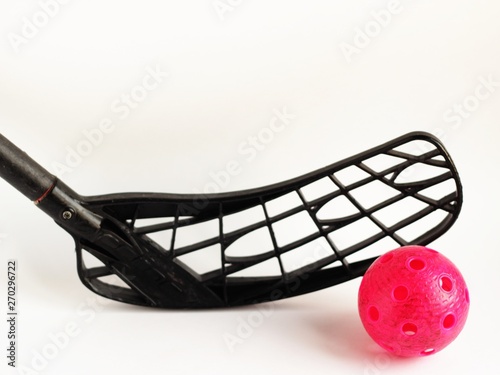 physical education and sport concept. sports games. close up black floorball stick and red ball isolated on white background. copy space for text.