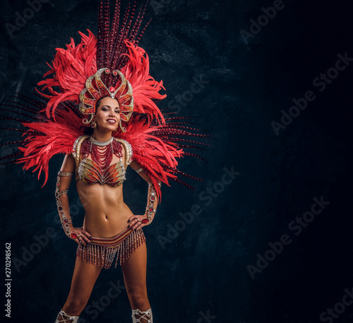 Fotografia Happy beautiful brasil dancer in red feather costume is dancing on small scene