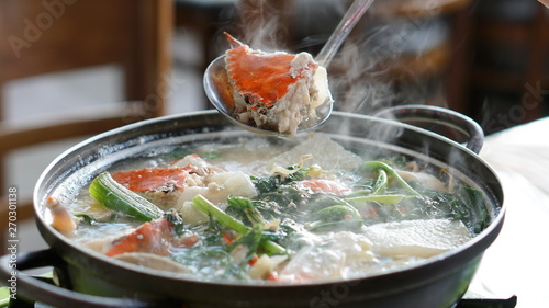 Boiling seafood soup with shrimps, crabs, clams and vegetables cooked in Jagalchi fish market in South Korea in Busan. photo