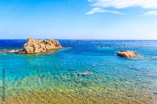 Rocks in crystal clear azure sea near beach on Karpathos island near Ammopi village, Greece