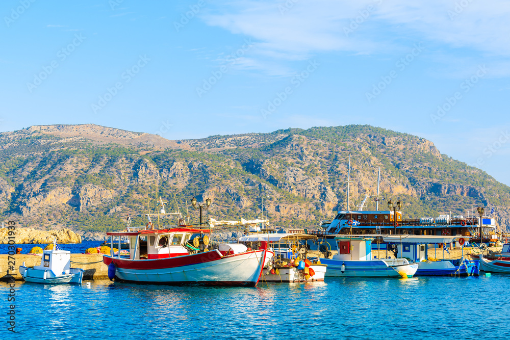 Boats in beautiful Pigadia fishing port with mountains in background, Karpathos island, Greece
