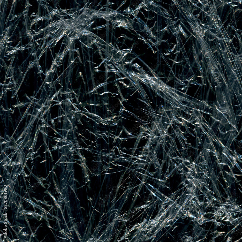 Transparent plastic wrap on the black background. Plastic bag texture. Reusable trash and waste. Transparent plastic wrap on the black background. Plastic bag texture. Reusable trash and waste.