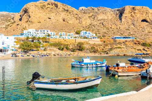 Fishing boats in picturesque Finiki port with mountains in background  Karpathos island  Greece