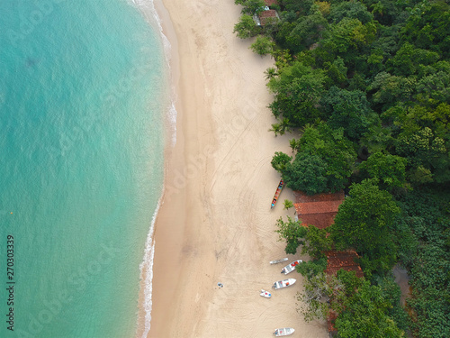 Aerial view of an amazing white sandy beach with turquoise water in tropical country. Amazing top view of sandy tropical beach. holiday destination. Palm and tropical beach with crystal clear water.