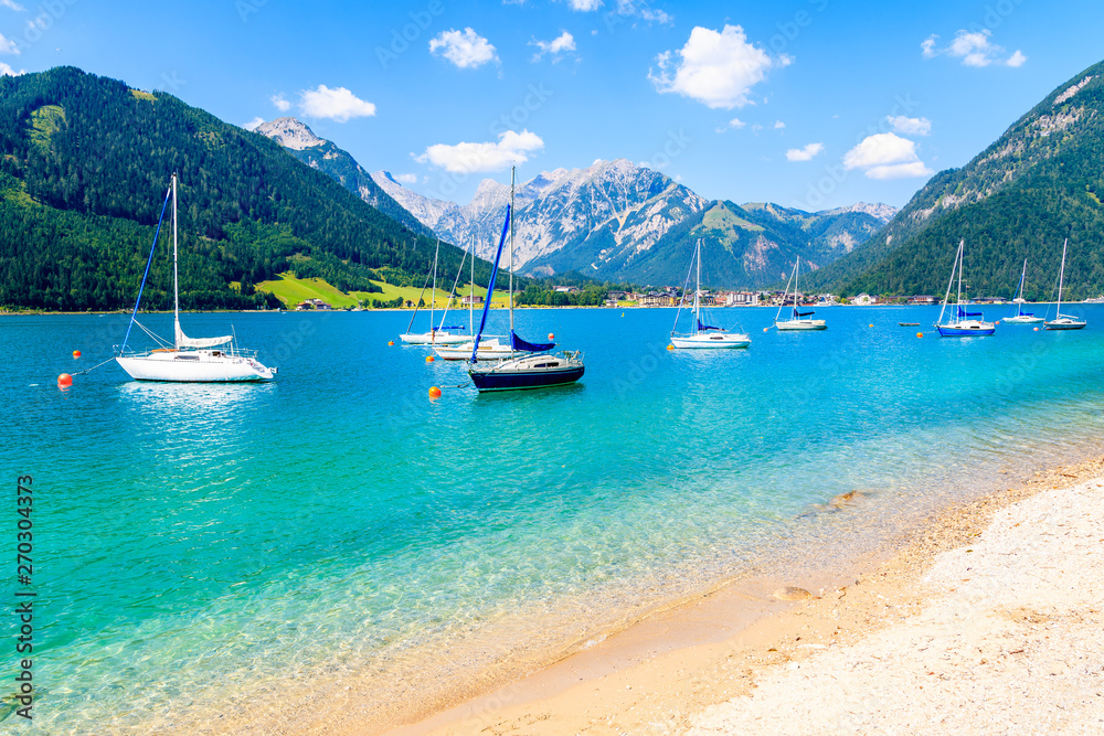 Fototapeta premium Sailing boats and view of beach near Pertisau town at beautiful Achensee lake on sunny summer day, Tirol, Austria