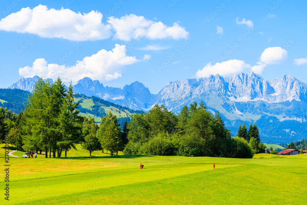 Green golf course area against mountains background on sunny summer day, Kitzbuhel, Tyrol, Austria