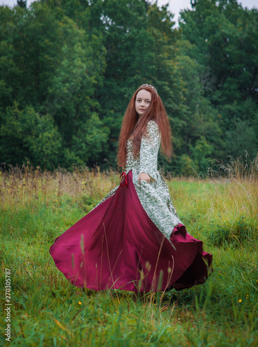 Beautiful happy woman in long medieval dress dancing