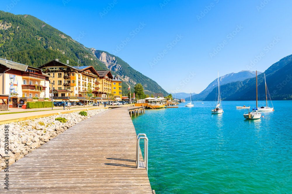 ACHENSEE LAKE, PERTISAU - JUL 31, 2018: Pier on shore of beautiful Achensee lake on sunny summer day with blue sky, Karwendel mountain range, TIrol, Austria.