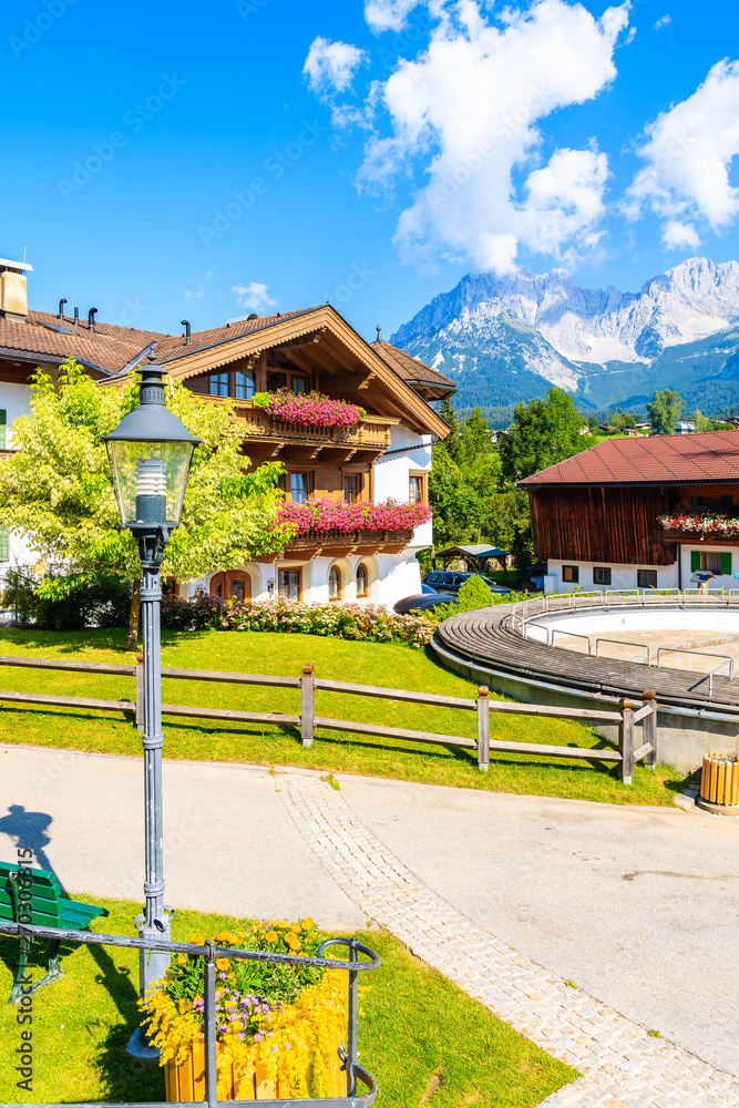 Traditional alpine houses on square in village of Going am Wilden Kaiser on beautiful sunny summer day with Alps mountains in background, Tirol, Austria Traditional alpine houses on square in village of Going am Wilden Kaiser on beautiful sunny summer day with Alps mountains in background, Tirol, Austria