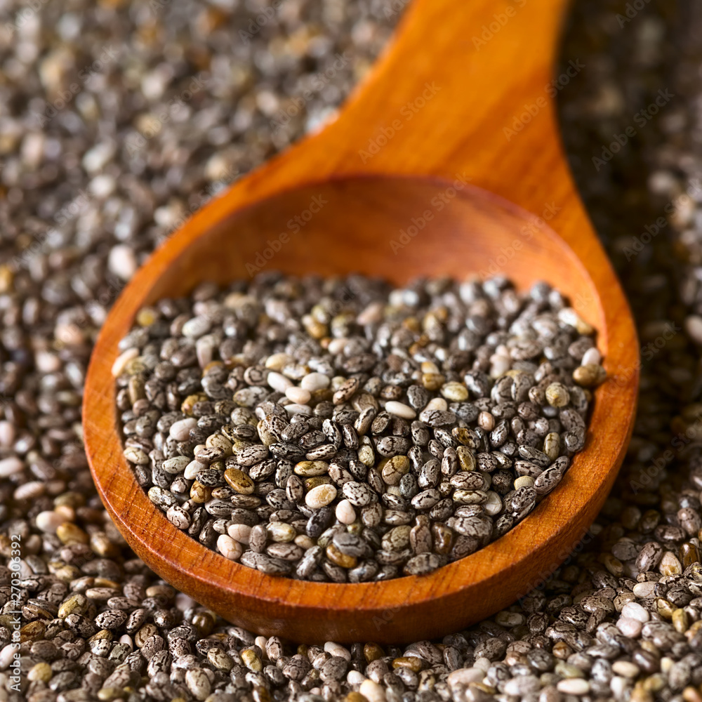 Healthy chia seeds (lat. Salvia hispanica) on wooden spoon, photographed with natural light (Selective Focus, Focus one third into the chia seeds on the spoon) Healthy chia seeds (lat. Salvia hispanica) on wooden spoon, photographed with natural light (Selective Focus, Focus one third into the chia seeds on the spoon)