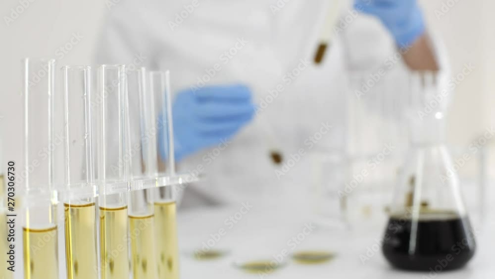 Scientist tearing the CBD oil from one tube into another Scientist tearing the CBD oil from one tube into another