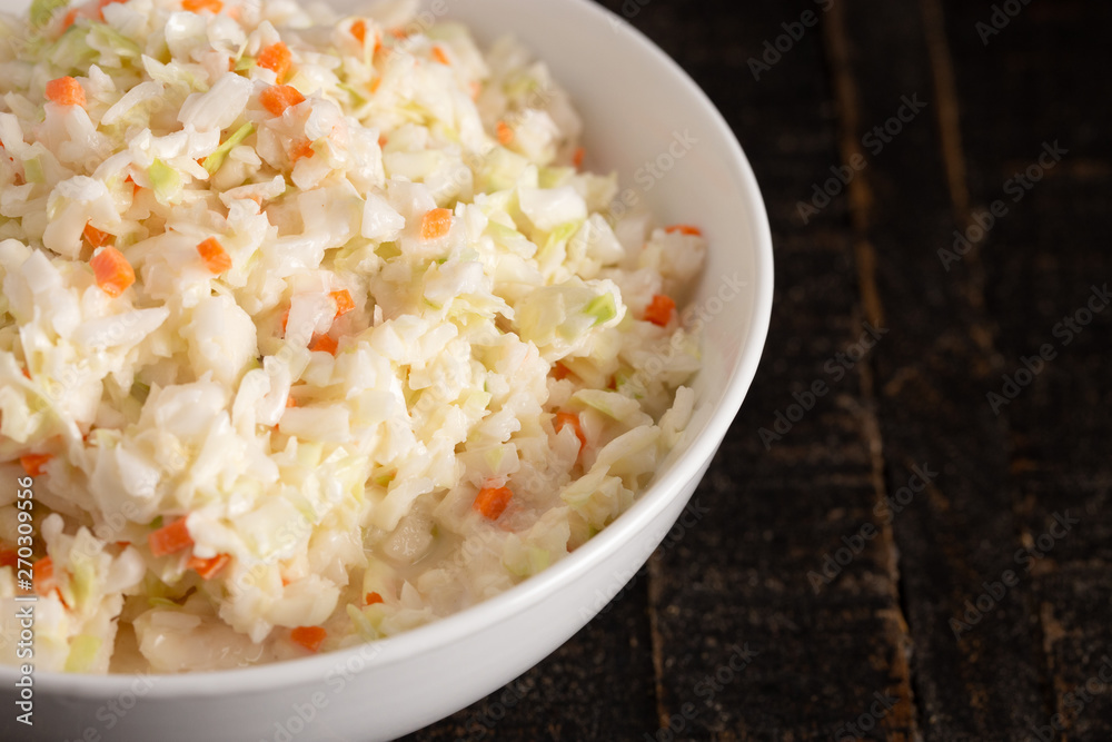 Bowl of Coleslaw on a Rustic Wooden Table Bowl of Coleslaw on a Rustic Wooden Table