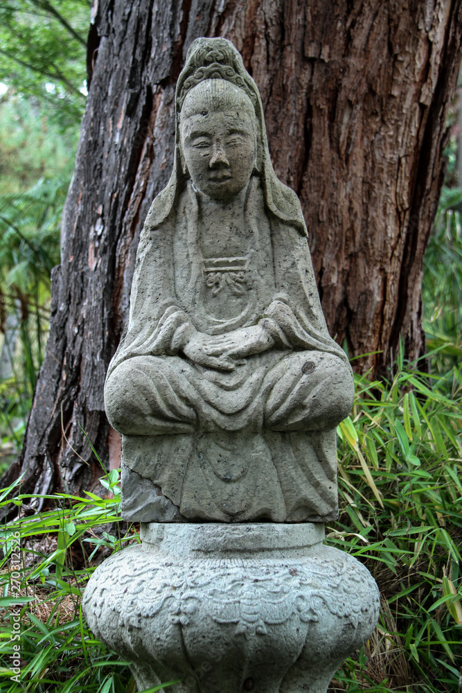 Asian statue in garden setting