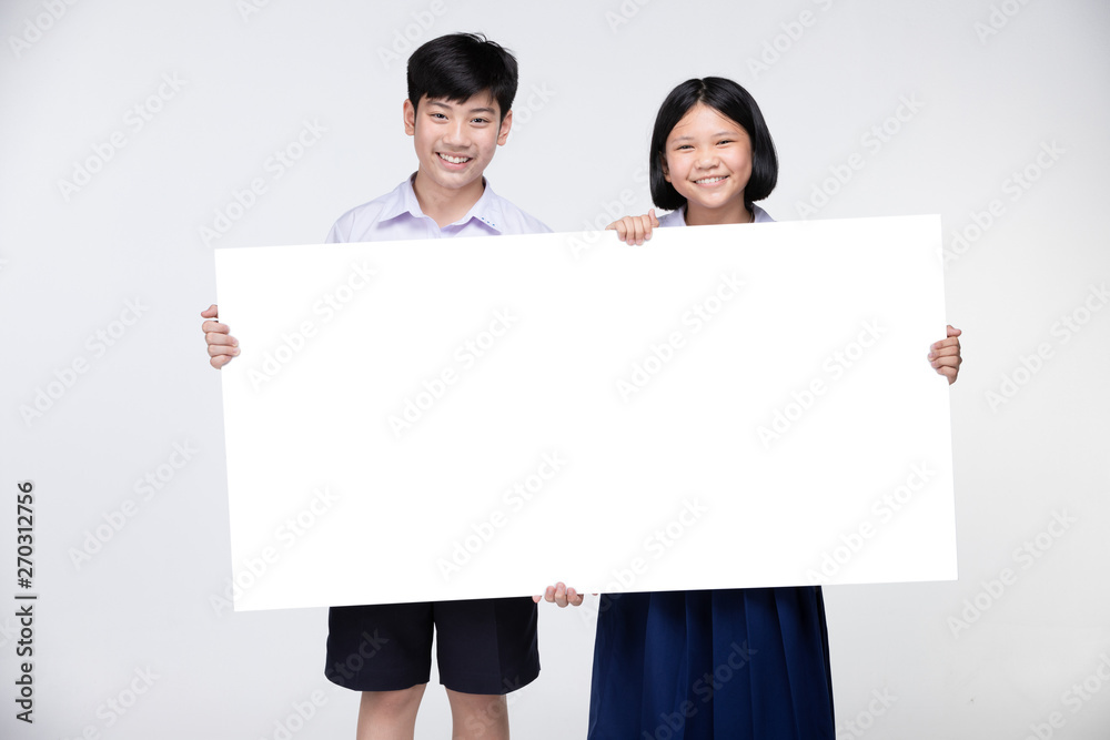 Cute Asian kids in student's uniform with white board. Cute Asian kids in student's uniform with white board.