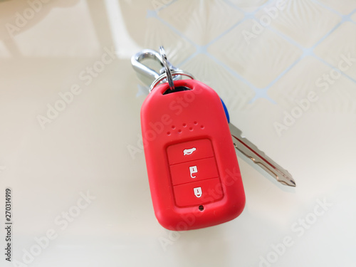 Car remote key wrapped in bright red silicone placed on the table. photo