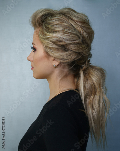 Young attractive blonde girl with hairstyle and make-up. Portrait after visiting beauty salon.