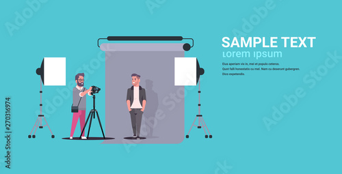 professional photographer using camera shooting business man in formal wear model posing in modern photo studio interior horizontal full length flat copy space