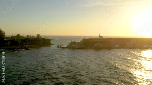 Drone flying over ocean at sunset towards Cape Arago Lighthouse at the Oregon Coast near Coos Bay and Charleston. photo