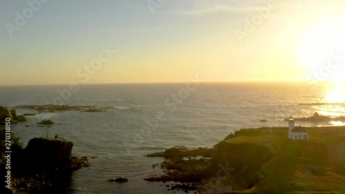 Drone flying over Cape Arago Lighthouse at the Oregon Coast near Coos Bay and Shore Acres, during sunset. photo